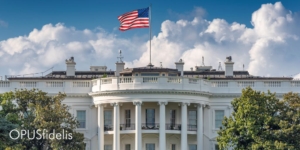 Exterior shot of the White House, flag waving.