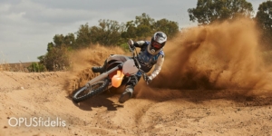 A dirt biker rounds a corner on a course.
